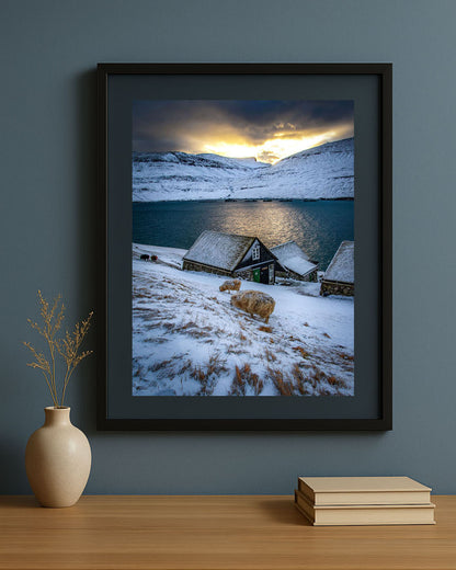 Framed photography print of winter in Bøur village, Faroe Islands, displayed on a wall